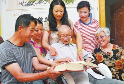 一家人圍在一起，饒有興趣地翻閱永定蘇氏族譜。
