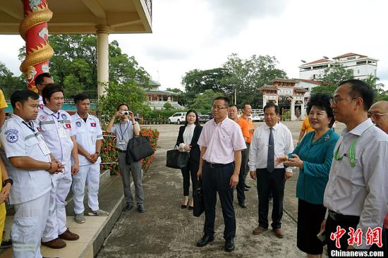 中國國務院僑辦主任裘援平，8日來到位于老撾永珍善堂的萬象華助中心考察。她強調(diào)，要通過各方面共同努力，把海外華助中心打造成僑胞守望相助的“溫暖之家”。圖為裘援平與華助中心救助隊員交流。<a target='_blank' >中新社</a>記者 齊彬 攝