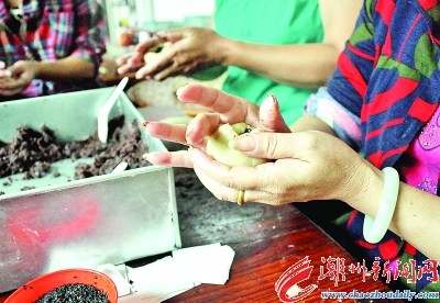 包餡，取小面團手工捏開后放進豆泥餡料，包捏起來。