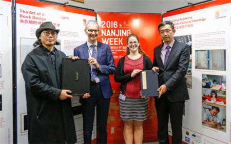 南京市委宣傳部副部長(zhǎng)潘谷平(右一)、書(shū)籍裝幀設(shè)計(jì)師朱贏椿(左一)向大英圖書(shū)館贈(zèng)送禮物。