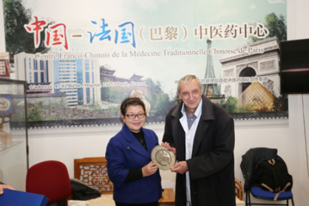 熊磊校長向包默魯主任贈送云南中醫(yī)學院紀念盤。（圖片來源：本版照片均由黃冠杰 攝）