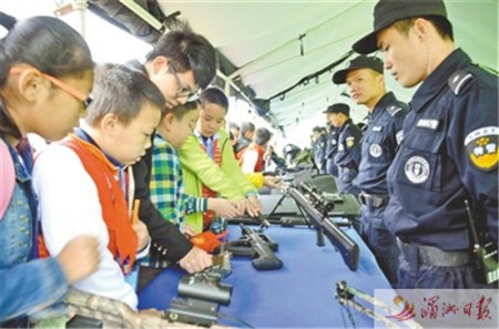 日前，市公安局舉行警營開放日，邀請各界群眾代表走進警營，體驗警營生活、了解公安工作，進一步促進警民關系。圖為部分學生代表正在了解槍械知識。 記者 吳偉鋒 攝