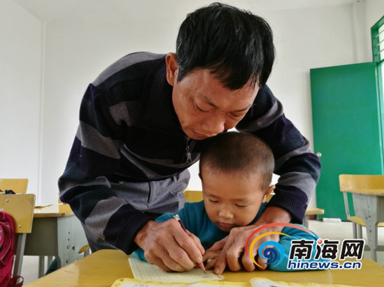 吳光明教孩子們寫字。南海網(wǎng)記者 高鵬 攝