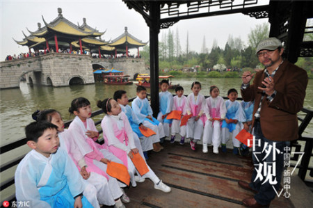 2016年4月2日，江蘇揚州瘦西湖景區(qū)，央視詩詞大會擂主給揚州市汶河小學國學班的孩子們講授有關(guān)揚州詩詞，孩子們身著古裝，跟隨夏昆老師邊游邊學，孩子們在充分游覽的同時學習國學文化。(劉江瑞)