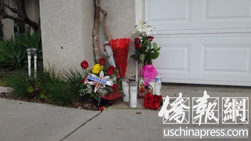 門(mén)口擺放著長(zhǎng)明燈和鮮花，表達(dá)了人們對(duì)受害者黃閔的追思和悼念。(美國(guó)《僑報(bào)》/高睿 攝)