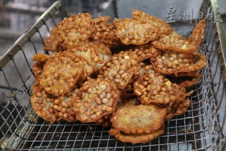 花生餅從油鍋中撈上來，呈金麥色的色澤。（馬來西亞《星洲日報》）