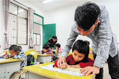 吳志平教學(xué)生寫字，父親吳光明也沒有閑著。