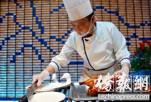 眉州東坡的烤鴨有特色，一位師傅在片烤鴨肉。(僑報記者邱晨攝)