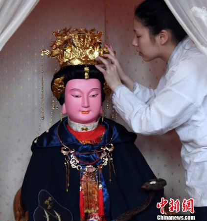 一名福州三坊七巷郎官巷天后宮道士更衣沐手、上香拜謁后為媽祖軟身神像戴上鳳冠?！∮浾邉⒖筛?攝