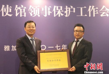 圖為謝鋒為2016年度領(lǐng)保聯(lián)絡(luò)員工作先進(jìn)合作單位——印尼中國(guó)商會(huì)總會(huì)頒發(fā)獎(jiǎng)牌。林永傳　攝