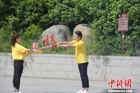 圣火采集手將火種對準圣火采集器，點亮火種燈。沈春艷 攝