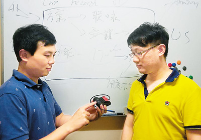吳偲越（左一）與合伙人在討論行車記錄儀的上市方案。