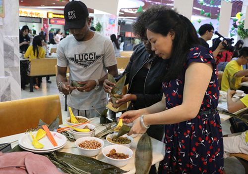 境外生認真地向老師學(xué)包粽子