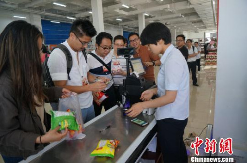 圖為華裔青年排隊為購買的進口商品付賬?！№n章云 攝