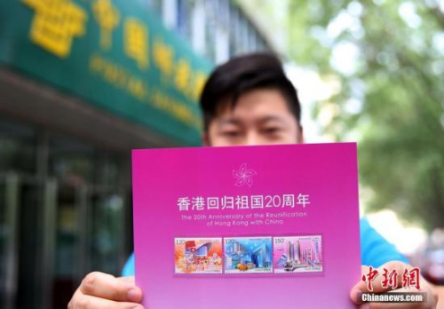 資料圖：2017年7月1日，北京集郵愛好者展示《香港回歸祖國二十周年》紀念郵票。當日，為慶祝香港回歸祖國二十周年，中國郵政發(fā)行《香港回歸祖國二十周年》紀念郵票。 <a target='_blank' >中新社</a>記者 卞正鋒 攝