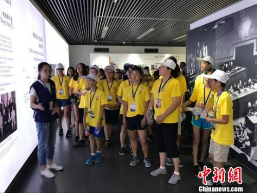 華裔師生參觀紀(jì)念館展廳，聽(tīng)工作人員講解歷史。 江蘇省僑辦