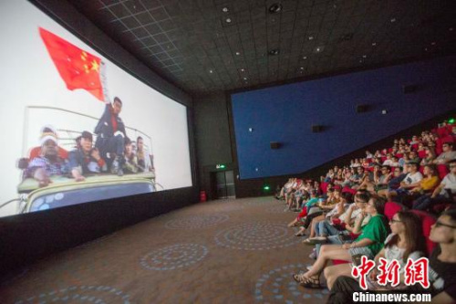 資料圖：影片《戰(zhàn)狼》中冷鋒（男主角）舉著中國國旗安全通過交戰(zhàn)區(qū)?！?jiān)啤z