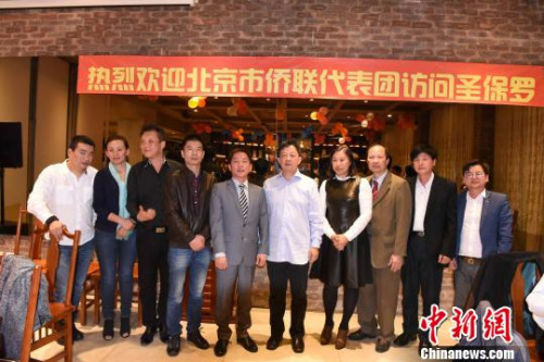 圖為北京市僑聯(lián)副主席蘇泳(左六)與當(dāng)?shù)厝A人僑領(lǐng)合影?！∧尚?攝