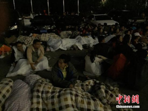 圖為九寨溝景區(qū)內(nèi)，許多游客不敢繼續(xù)待在酒店內(nèi)，裹著厚衣服和毛毯來(lái)到街上席地而睡。 徐廣 攝