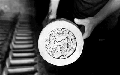 古都國(guó)華琉璃廠經(jīng)理孫宏利展示琉璃半成品上刻有的圖案。停產(chǎn)后，廠子只能將部分半成品運(yùn)到山西進(jìn)行二次加工
