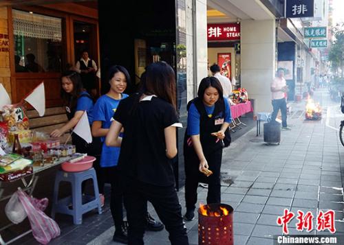 圖為處處可見民眾臨街擺放祭祀品，點燃香火虔誠祭拜，隨后給先人焚燒紙錢，祈求風調雨順、家庭幸福，街頭節(jié)日氣氛非常濃厚。 <a target='_blank' >中新社</a>記者 蔣雪林 攝