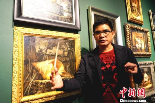 畫展的主人、菲律賓畫家阿瑞奧拉(DANILO ARRIOLA)每天坐在輪椅上迎接參觀者。 關(guān)向東 攝