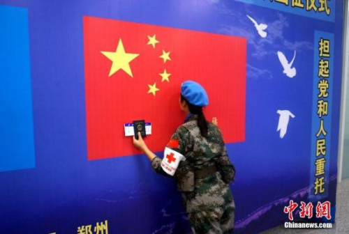 一名維和女兵出征前親吻五星紅旗。 李志全 攝