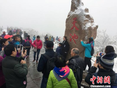 游客在天池邊合影?！≌缑贰z