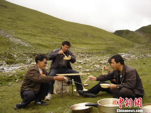 第六地質(zhì)大隊隊員們在曠野外就餐?！≈芪脑?攝