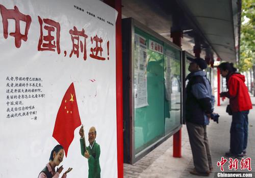 資料圖：北京市民在一個(gè)閱報(bào)欄前關(guān)注十八屆三中全會(huì)的新聞報(bào)道。<a target='_blank' >中新社</a>發(fā) 張浩 攝