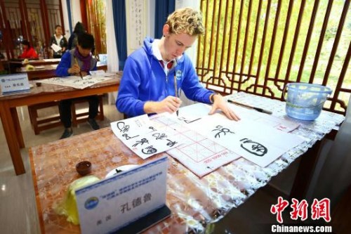 圖為營員體驗東巴字畫?！⊥踽恕z
