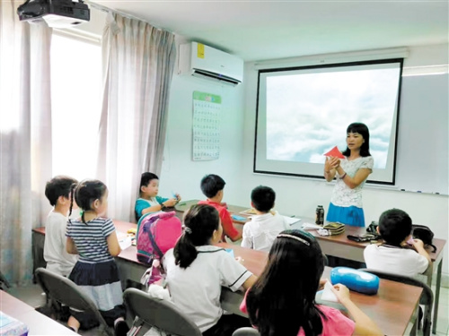 陳小清給學(xué)生上剪紙課。