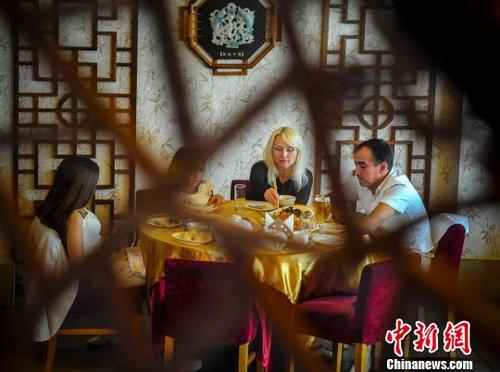 外國食客在享用中國美食。（<a target='_blank'  >中新網(wǎng)</a>記者 劉新 攝）