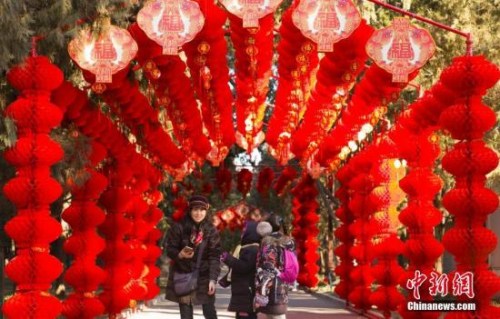 資料圖：2018年2月2日，北京地壇公園，市民經(jīng)過掛滿紅燈籠的通道。隨著農(nóng)歷春節(jié)的臨近，北京城年味漸濃。<a target='_blank' >中新社</a>記者 侯宇 攝