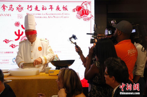 當(dāng)?shù)貢r(shí)間2月15日新春除夕夜，一餐“行走的年夜飯”拉開了巴拿馬華人社區(qū)慶祝中巴建交后首個(gè)農(nóng)歷新年一系列活動(dòng)的大幕。圖為廚藝大師現(xiàn)場(chǎng)展示“蒙眼墊布切炒麥穗魷魚”絕活兒。2018年“歡樂(lè)春節(jié)·行走的年夜飯”活動(dòng)由北京百年老字號(hào)“全聚德”和“東來(lái)順”組建廚藝大師團(tuán)隊(duì)，為巴拿馬當(dāng)?shù)赜押萌耸亢吐冒蛢S胞展現(xiàn)中華傳統(tǒng)烹飪技藝精萃，年夜飯菜點(diǎn)則精選中國(guó)各大菜系精華。<a target='_blank' >中新社</a>記者 余瑞冬 攝