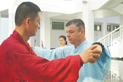 林方卿(左一)指導(dǎo)謝志明學(xué)習(xí)太極拳。