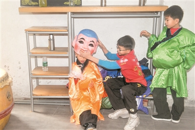 學(xué)習(xí)了一個上午的大頭佛表演，小學(xué)徒在一旁休息。