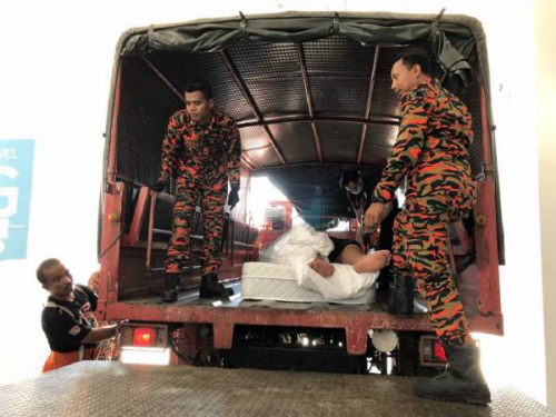 華裔男子被抬上卡車送往醫(yī)院。（馬來西亞《中國報》）