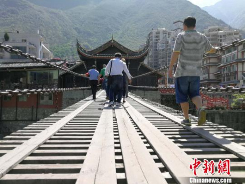 圖為海外華文媒體代表走過瀘定橋?！钭谂?攝