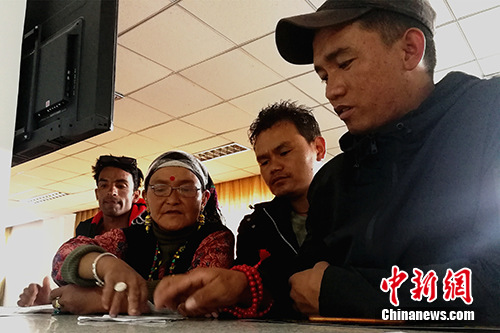圖為今年57歲的尼泊爾商人贊達(dá)熱·瓦迪(左二)在阿里獅泉河海關(guān)普蘭工作點(diǎn)的業(yè)務(wù)大廳內(nèi)辦理通關(guān)手續(xù)。<a target='_blank' >中新社</a>記者 趙延 攝