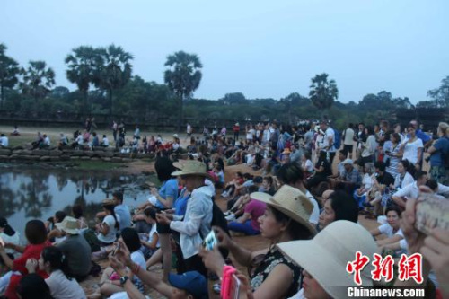 資料圖：國際游客守候在吳哥窟景區(qū)觀看日出?！×蚊艏?攝