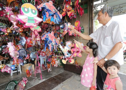 羅進(jìn)錫每年中秋節(jié)，都會(huì)帶著孫女到商店選購(gòu)喜愛的燈籠。（馬來西亞《星洲日?qǐng)?bào)》）