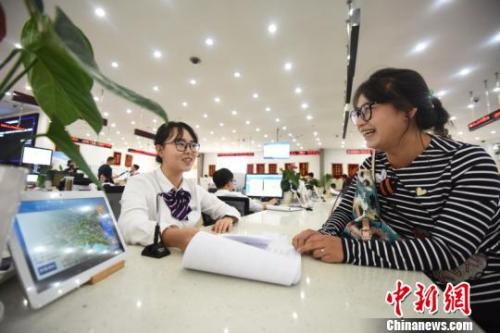 資料圖：居民正在行政審批柜臺辦理手續(xù)?！⑩x 攝