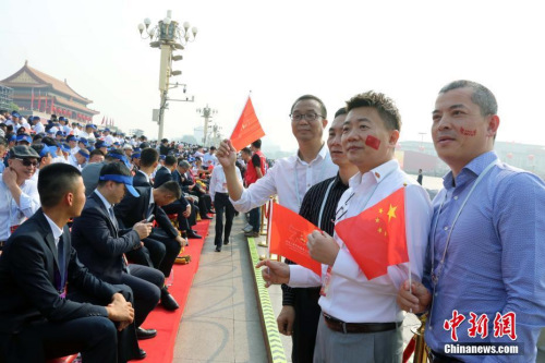 10月1日，慶祝中華人民共和國成立70周年大會(huì)在北京隆重舉行。約2000名海外華僑華人在現(xiàn)場見證了歷史時(shí)刻。他們表示，國慶慶典展現(xiàn)了中華民族的自信和威嚴(yán)，凝聚起了全球僑胞的心。圖為來自巴布亞新幾內(nèi)亞的薛輝雄等在觀禮臺(tái)合影。<a target='_blank' >中新社</a>記者 任海霞 攝