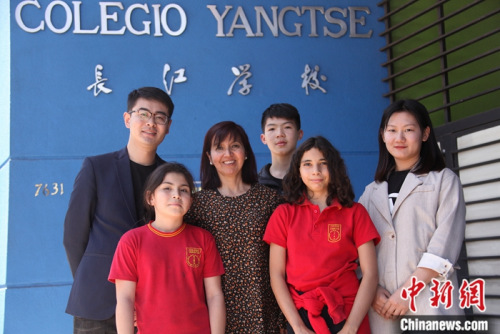 圖為11月6日，長江學校校長羅哈斯(Marcela Rojas Cantillana，左三)、國家漢辦駐智利漢語教師志愿者管理教師劉昌(左一)、長江學校中文老師李媛媛(右)與學生們在學校門前合影。<a target='_blank' >中新社</a>記者 余瑞冬 攝