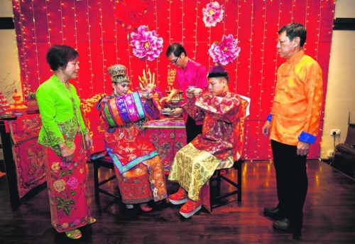 新郎的父親李榮佳(右一)在給兒子操辦婚禮時(shí)，特地前往馬六甲重金禮聘傳統(tǒng)婚禮禮儀師，而部分古董和珠寶是來自他個(gè)人及友人的收藏。多方奔走后，最終圓滿舉行了一場遵循傳統(tǒng)習(xí)俗的婚禮。 (新加坡《聯(lián)合早報(bào)》/梁麒麟 攝)