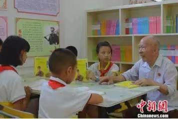 鐘挺華在東安二小圖書館為學(xué)生講雷鋒故事。嚴(yán)潔 攝