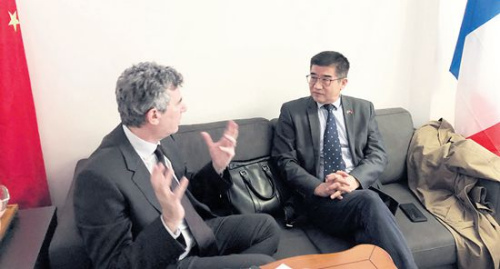 　　正在和客人商討前往中國計劃的周建防(右)。(《歐洲時報》/黃冠杰 攝)