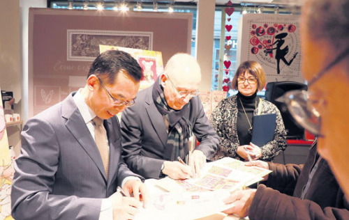 　　盧沙野大使(左)、菲利普·瓦爾總裁為集郵愛好者簽名留念。(《歐洲時報》/歐文 攝)