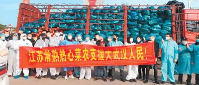 　　支援武漢的江蘇常熟菜農(nóng)及其他人員在運(yùn)輸貨車前合影。（東敏佳供圖）